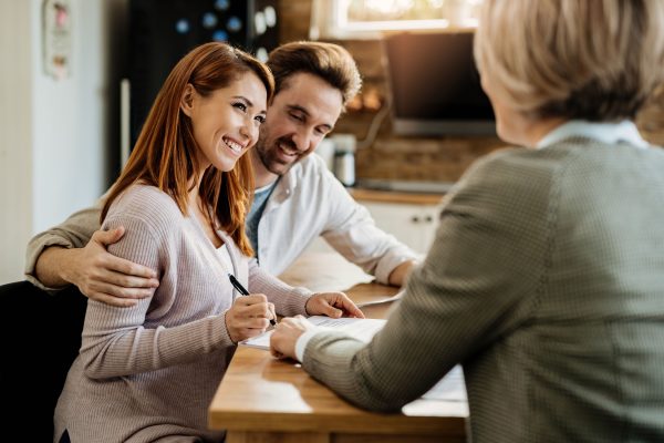 young-happy-woman-her-husband-signing-agreement-with-insurance-agent-meeting